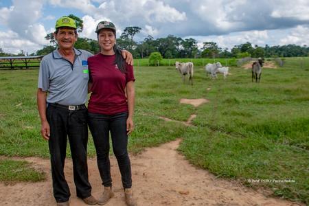 Photo of two farmers in a field with cattle