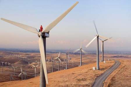 Worker standing on wind turbine at wind farm