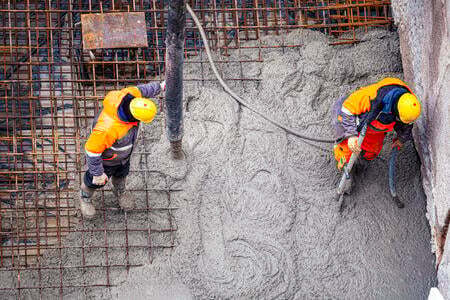 Image of two concrete workers standing on foundation