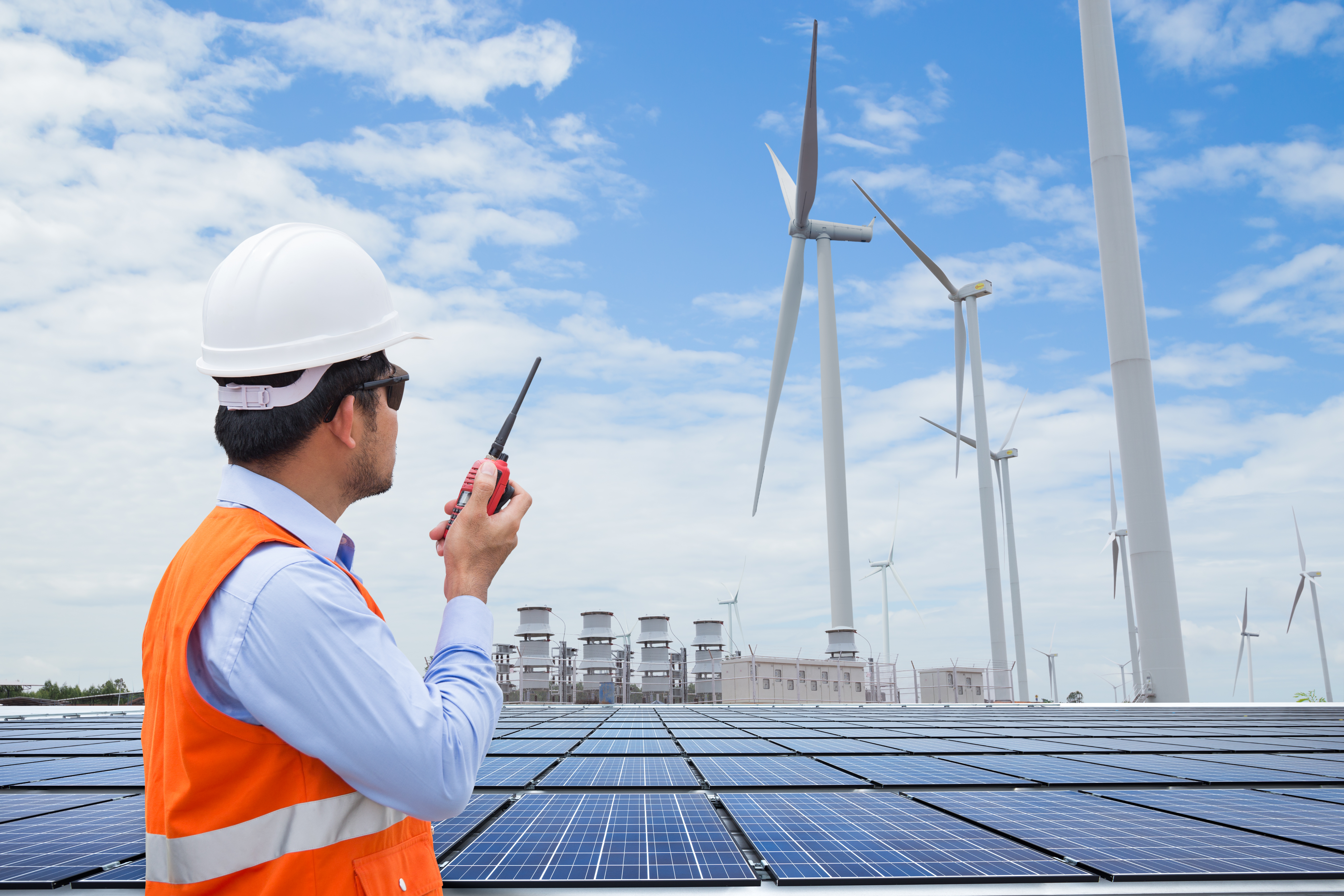 Man overlooking wind farm and solar panels